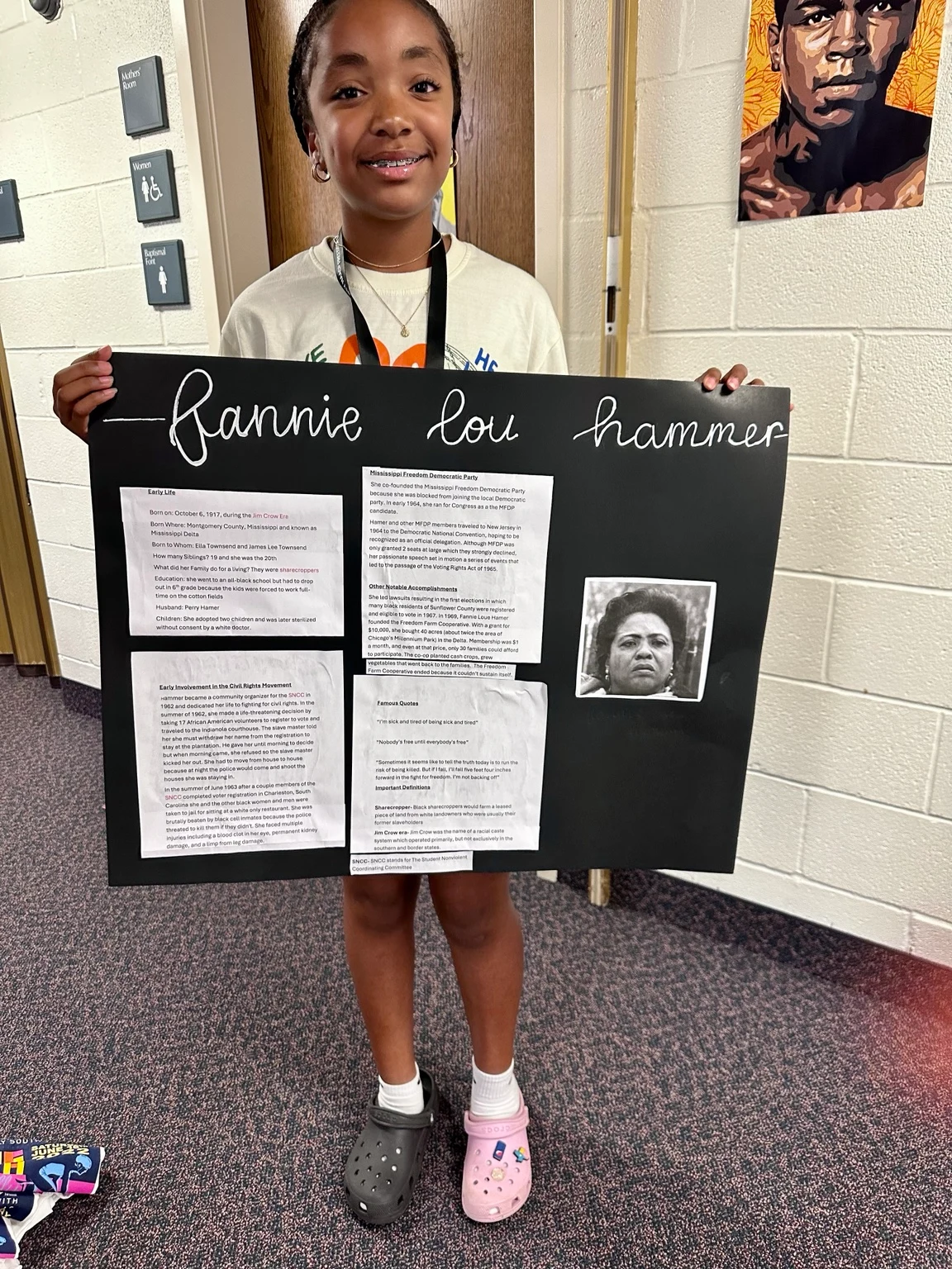 A Freedom School scholar holding a research poster about Fannie Lou Hamer